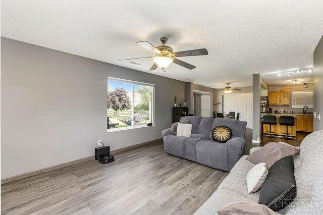 6706 Bedington Ln, Morrow, OH 45152 - living room with light wood-style flooring, ceiling fan, and a textured ceiling