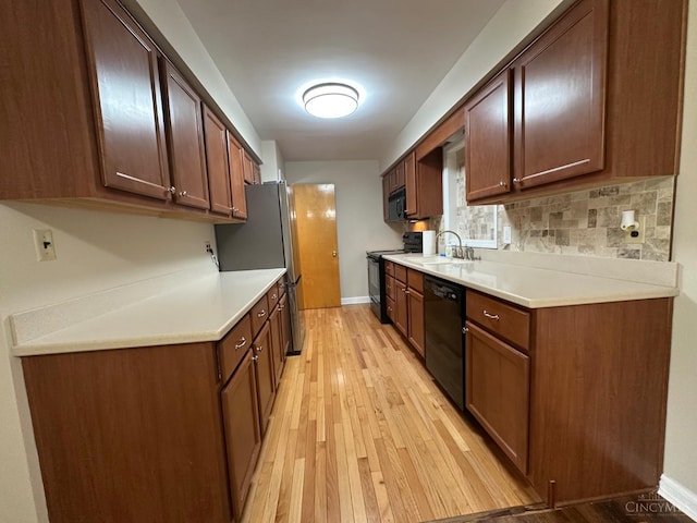 1285 Oakmont Dr, Hamilton, OH 45013 - kitchen featuring black appliances, light wood-style flooring, light countertops, and backsplash