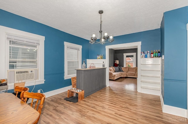 609 Coralie Ave, Hamilton, OH 45013 - dining room featuring cooling unit, a chandelier, wood finished floors, and a textured ceiling