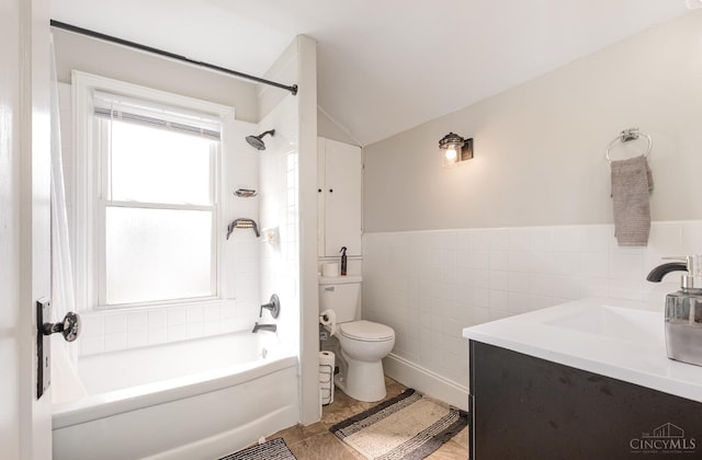 609 Coralie Ave, Hamilton, OH 45013 - bathroom featuring tile walls, vanity,  shower combination, vaulted ceiling, and wainscoting