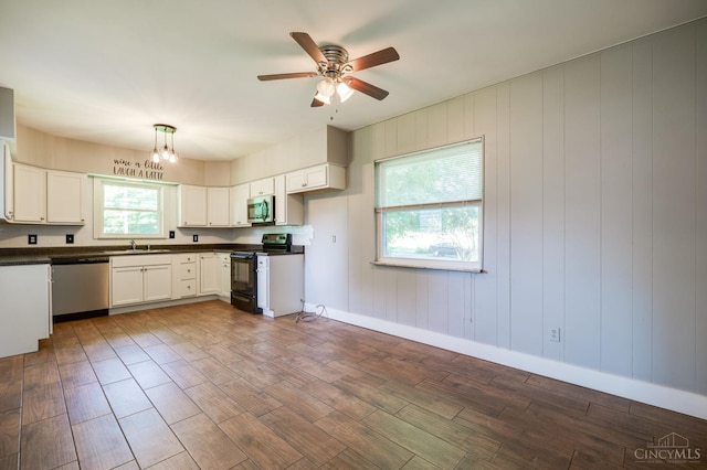 732 Central Ave, Carlisle, OH 45005 - kitchen with stainless steel appliances, dark countertops, dark wood finished floors, ceiling fan, and white cabinets