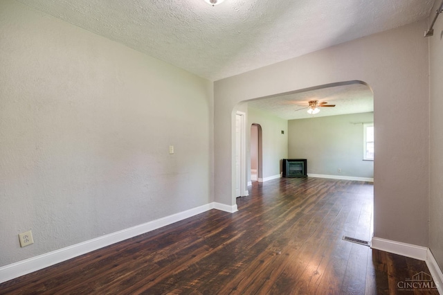 732 Central Ave, Carlisle, OH 45005 - unfurnished living room featuring arched walkways, dark wood finished floors, a ceiling fan, and a textured ceiling