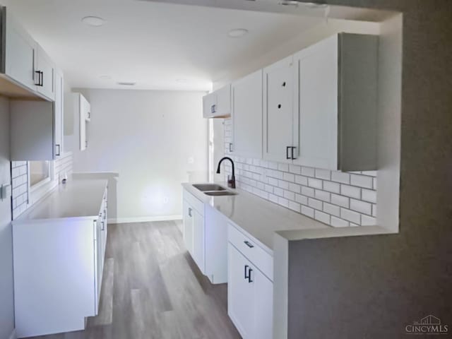 1048 S James Rd, Columbus, OH 43227 - kitchen featuring decorative backsplash, wood finished floors, white cabinetry, and light countertops