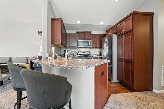 7981 Oakbridge Way, Green Twp, OH 45248 - kitchen with appliances with stainless steel finishes, a peninsula, a kitchen bar, recessed lighting, and dark wood-style flooring
