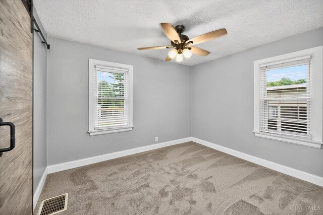 4644 Alpine Ave, Blue Ash, OH 45242 - carpeted empty room with a textured ceiling, a ceiling fan, and a barn door