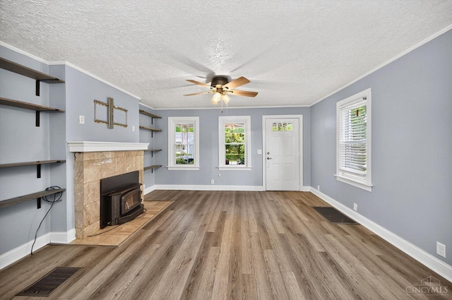4644 Alpine Ave, Blue Ash, OH 45242 - unfurnished living room with wood finished floors, ceiling fan, a textured ceiling, a wood stove, and crown molding