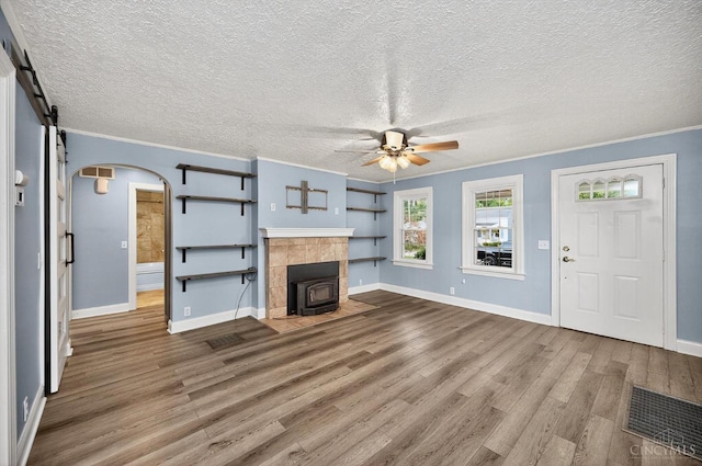 4644 Alpine Ave, Blue Ash, OH 45242 - unfurnished living room featuring wood finished floors, crown molding, a ceiling fan, a wood stove, and a textured ceiling