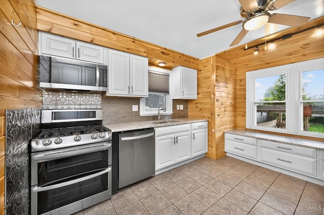 4644 Alpine Ave, Blue Ash, OH 45242 - kitchen featuring stainless steel appliances, white cabinetry, wooden walls, ceiling fan, and light stone counters