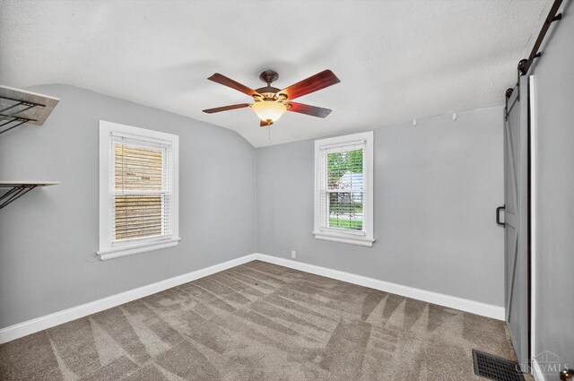 4644 Alpine Ave, Blue Ash, OH 45242 - unfurnished bedroom with vaulted ceiling, a barn door, carpet, and a ceiling fan