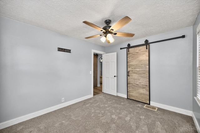 4644 Alpine Ave, Blue Ash, OH 45242 - unfurnished bedroom with a barn door, carpet floors, a ceiling fan, and a textured ceiling