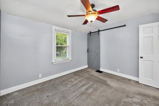 4644 Alpine Ave, Blue Ash, OH 45242 - unfurnished bedroom with a barn door, carpet floors, lofted ceiling, and ceiling fan