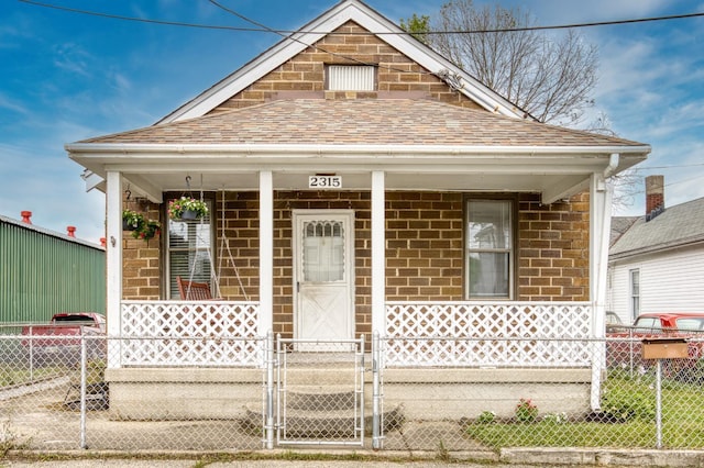 2315 Elbe Ave, Hamilton, OH 45015 - shotgun-style home with covered porch, a fenced front yard, a shingled roof, and a gate