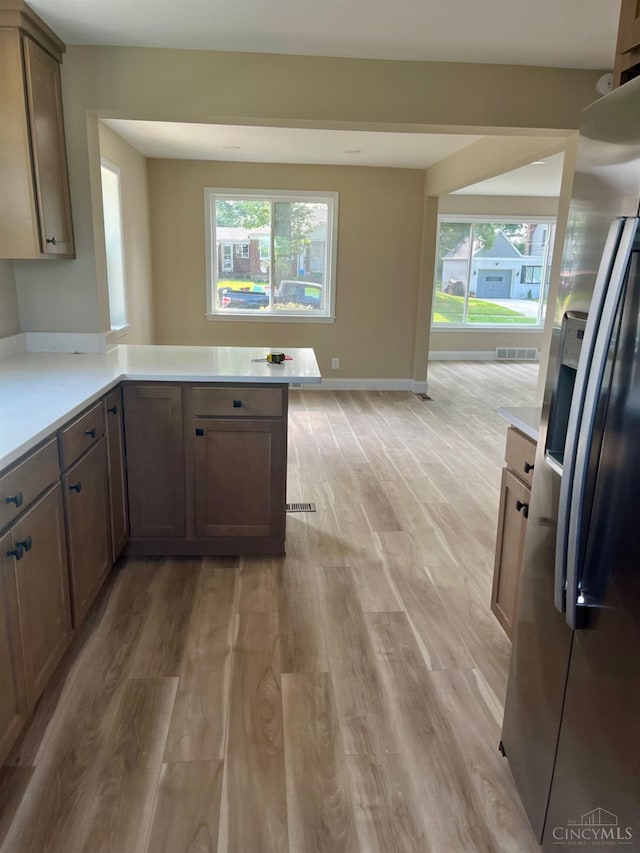 363 Don Ln, Delhi Twp, OH 45238 - kitchen featuring stainless steel fridge, light wood-style floors, light countertops, and a peninsula
