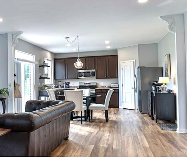 4623 Steeplechase Dr, Batavia Twp, OH 45103 - kitchen featuring stainless steel appliances, dark brown cabinetry, open floor plan, light countertops, and wood finished floors
