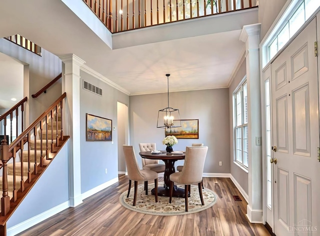 4623 Steeplechase Dr, Batavia Twp, OH 45103 - dining room with dark wood-style floors, ornamental molding, a chandelier, stairway, and decorative columns