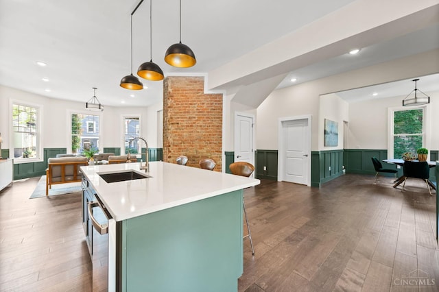 2241 Kemper Ln, Cincinnati, OH 45206 - kitchen with wainscoting, light countertops, dark wood-type flooring, an island with sink, and green cabinets