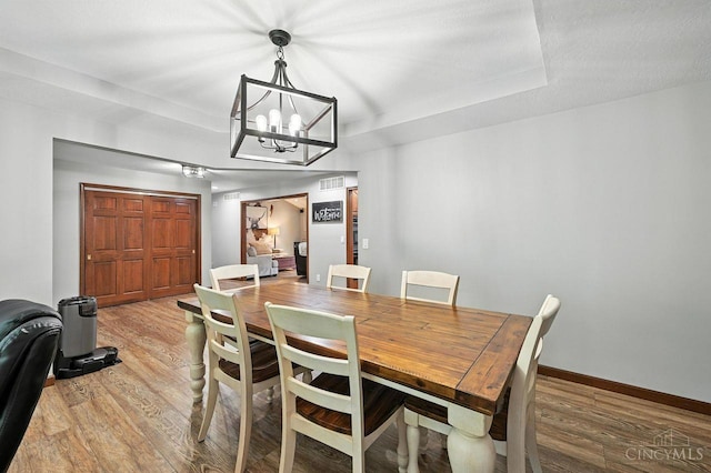 11545 Deer Trace Ln, Harrison Twp, OH 45030 - dining area with light wood-style flooring and a chandelier