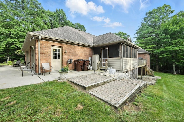 11545 Deer Trace Ln, Harrison Twp, OH 45030 - rear view of property featuring a sunroom, a patio, brick siding, a yard, and a shingled roof