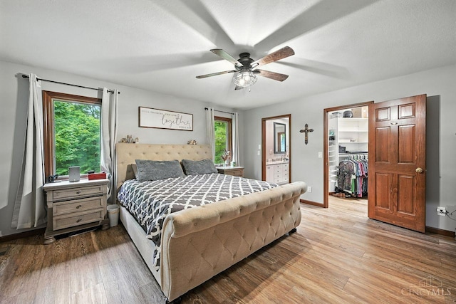 11545 Deer Trace Ln, Harrison Twp, OH 45030 - bedroom featuring a walk in closet, multiple windows, wood finished floors, and a closet