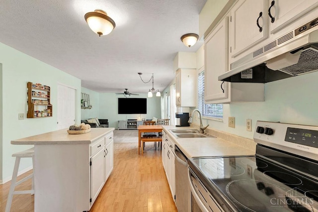 1165 Mcguffey Ln, Union Twp, OH 45103 - kitchen featuring appliances with stainless steel finishes, under cabinet range hood, ceiling fan, light wood-style floors, and a center island
