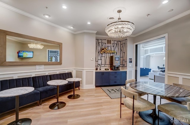 252 Stetson St Unit 403, Cincinnati, OH 45219 - dining space with a chandelier, crown molding, light wood finished floors, recessed lighting, and wainscoting