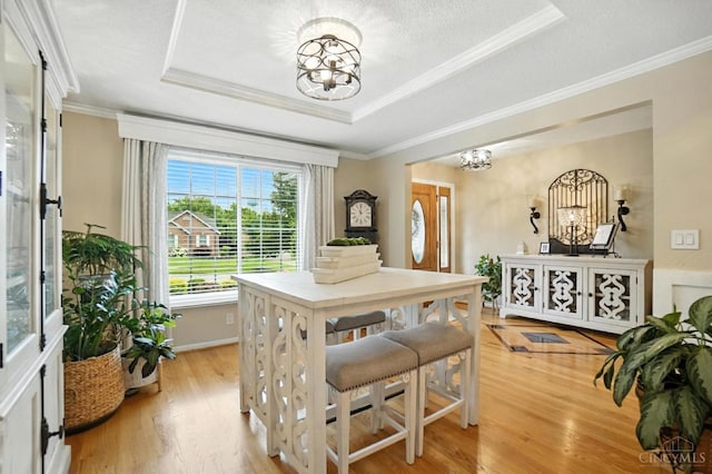 1751 Tatum Ln, Hamilton, OH 45013 - dining space with a chandelier, a raised ceiling, light wood-style flooring, and ornamental molding