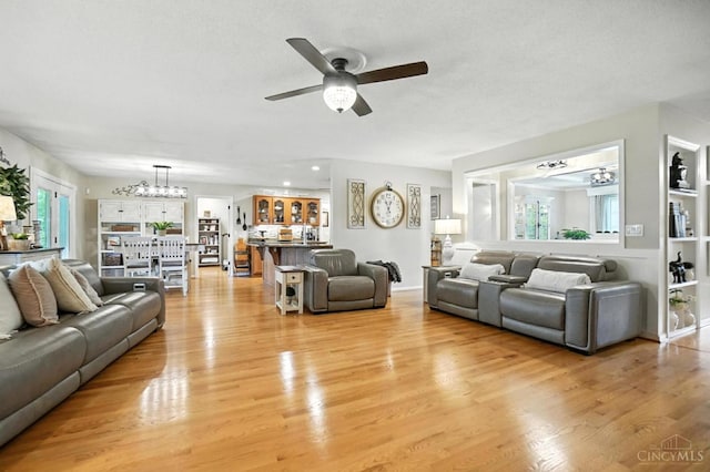 1751 Tatum Ln, Hamilton, OH 45013 - living room featuring a chandelier, ceiling fan, and light wood-style flooring