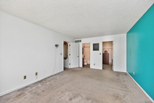 90 Lorelei Dr, Perry Twp, OH 45118 - unfurnished bedroom featuring carpet, a textured ceiling, ensuite bath, and a spacious closet