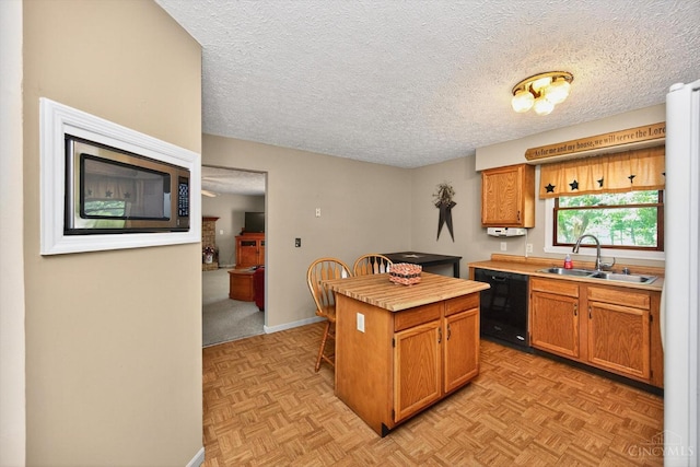 90 Lorelei Dr, Perry Twp, OH 45118 - kitchen featuring dishwasher, a kitchen island, a textured ceiling, light countertops, and a kitchen breakfast bar