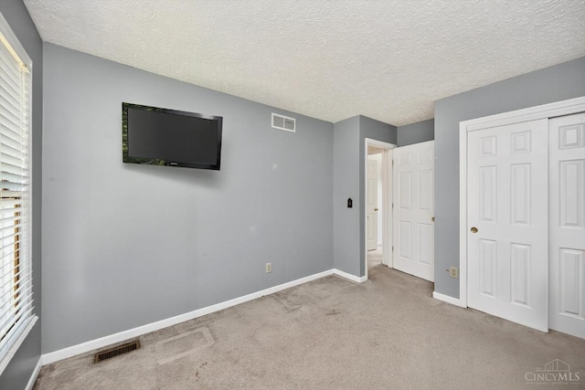 90 Lorelei Dr, Perry Twp, OH 45118 - unfurnished bedroom with carpet flooring, a closet, a textured ceiling, and multiple windows