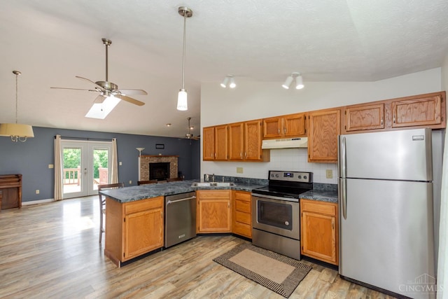 207 Valhalla Cv, Lakengren, OH 45320 - kitchen featuring stainless steel appliances, lofted ceiling, under cabinet range hood, dark countertops, and open floor plan