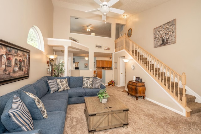 4247 Fieldsedge Dr, Mason, OH 45040 - living room featuring a high ceiling, stairway, carpet, a ceiling fan, and ornate columns