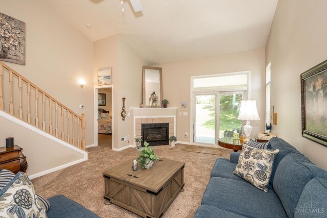 4247 Fieldsedge Dr, Mason, OH 45040 - living area featuring light colored carpet, ceiling fan, a tile fireplace, stairway, and high vaulted ceiling
