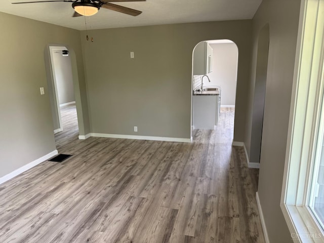 569 Beissinger Rd, Saint Clair Twp, OH 45013 - empty room with arched walkways, ceiling fan, and wood finished floors