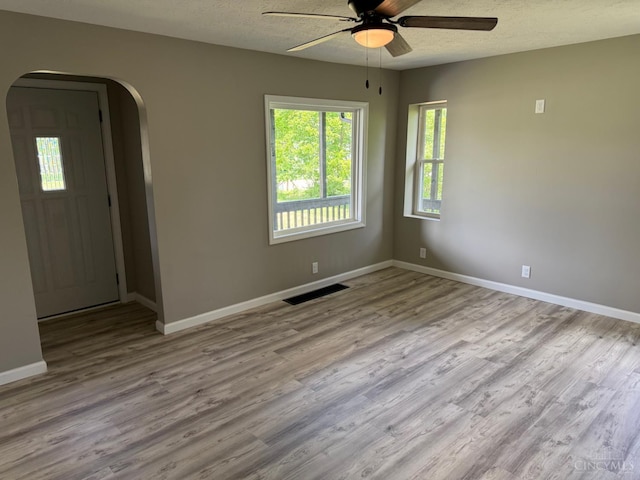 569 Beissinger Rd, Saint Clair Twp, OH 45013 - unfurnished room featuring arched walkways, ceiling fan, wood finished floors, and a textured ceiling