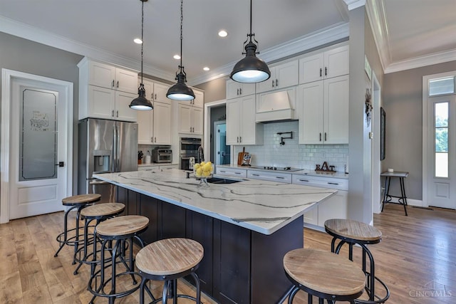 7948 Red Fox Trl, Hamilton Twp, OH 45152 - kitchen with custom range hood, stainless steel appliances, backsplash, light wood-style flooring, and white cabinets
