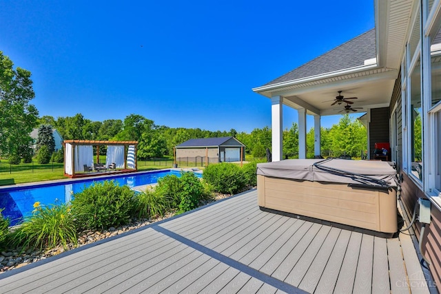7948 Red Fox Trl, Hamilton Twp, OH 45152 - deck with a hot tub, a ceiling fan, an outdoor pool, view of wooded area, and an outbuilding