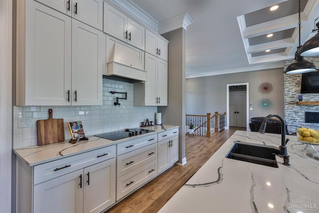 7948 Red Fox Trl, Hamilton Twp, OH 45152 - kitchen with ornamental molding, black electric cooktop, premium range hood, decorative backsplash, and white cabinetry
