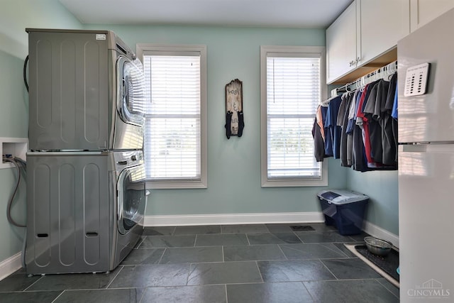 7948 Red Fox Trl, Hamilton Twp, OH 45152 - laundry area with stacked washer / drying machine and cabinet space
