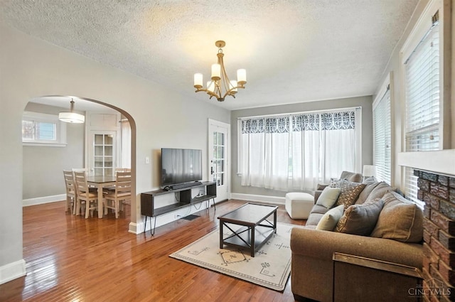 3462 Wabash Ave, Cincinnati, OH 45207 - living area featuring arched walkways, wood finished floors, a textured ceiling, and a chandelier