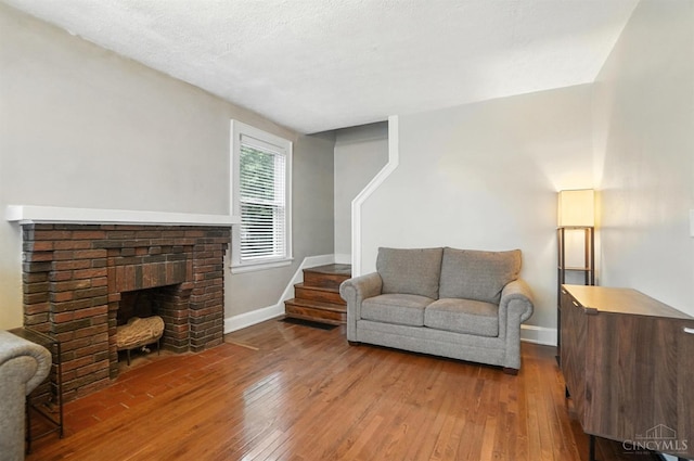 3462 Wabash Ave, Cincinnati, OH 45207 - living area featuring hardwood / wood-style flooring, stairway, and a brick fireplace