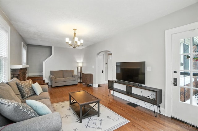 3462 Wabash Ave, Cincinnati, OH 45207 - living room with arched walkways, plenty of natural light, a chandelier, and wood finished floors