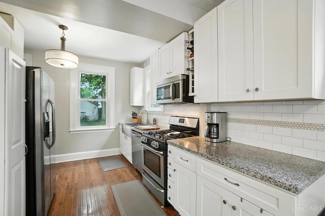 3462 Wabash Ave, Cincinnati, OH 45207 - kitchen with stainless steel appliances, dark wood-style floors, tasteful backsplash, white cabinetry, and light stone counters