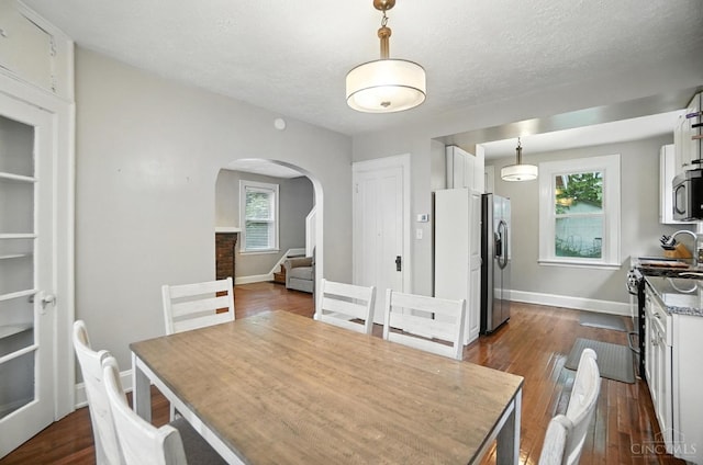 3462 Wabash Ave, Cincinnati, OH 45207 - dining space with arched walkways, dark wood finished floors, stairs, and a textured ceiling