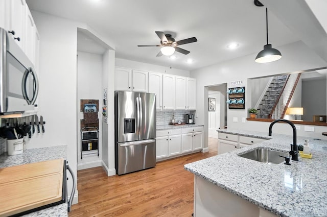 8608 Sunmont Dr, Anderson Twp, OH 45255 - kitchen with stainless steel appliances, a ceiling fan, light wood-style floors, white cabinetry, and recessed lighting