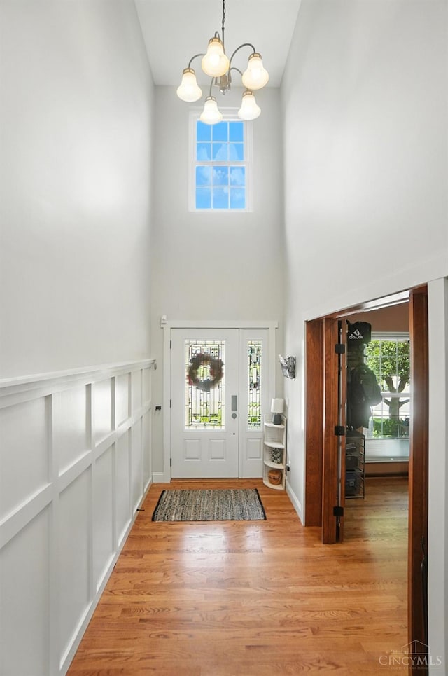 8608 Sunmont Dr, Anderson Twp, OH 45255 - foyer entrance featuring a towering ceiling, a chandelier, light wood finished floors, and healthy amount of natural light