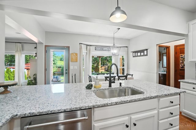 8608 Sunmont Dr, Anderson Twp, OH 45255 - kitchen with stainless steel dishwasher, white cabinetry, light stone countertops, hanging light fixtures, and wainscoting