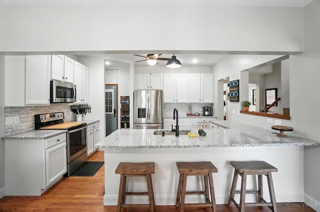 8608 Sunmont Dr, Anderson Twp, OH 45255 - kitchen with appliances with stainless steel finishes, a kitchen breakfast bar, backsplash, and recessed lighting