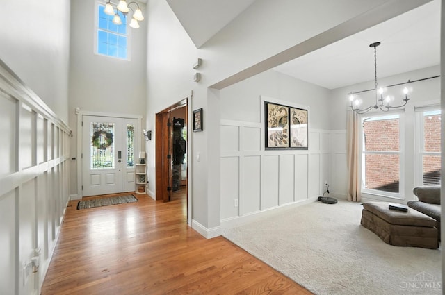 8608 Sunmont Dr, Anderson Twp, OH 45255 - foyer entrance featuring a chandelier, wood finished floors, a decorative wall, and a wainscoted wall