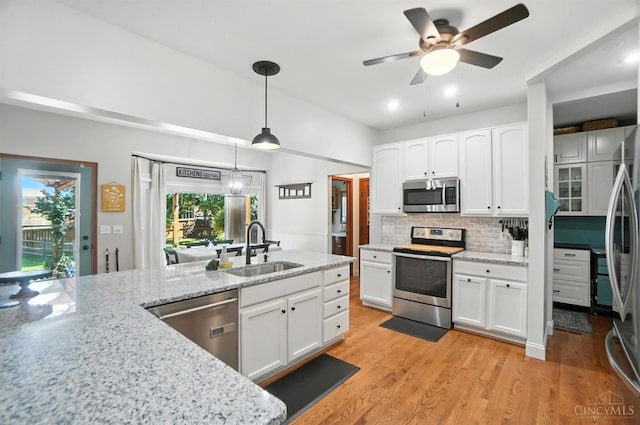 8608 Sunmont Dr, Anderson Twp, OH 45255 - kitchen featuring appliances with stainless steel finishes, white cabinets, ceiling fan, tasteful backsplash, and light stone counters
